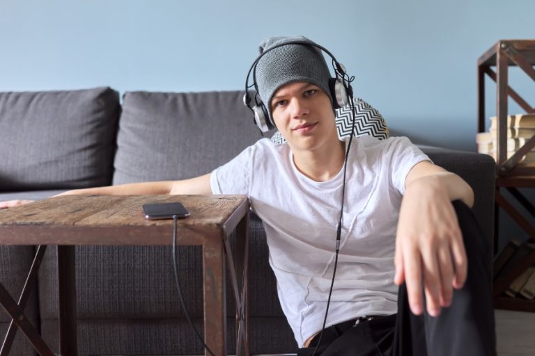 Portrait of hipster teenager in hat with headphones